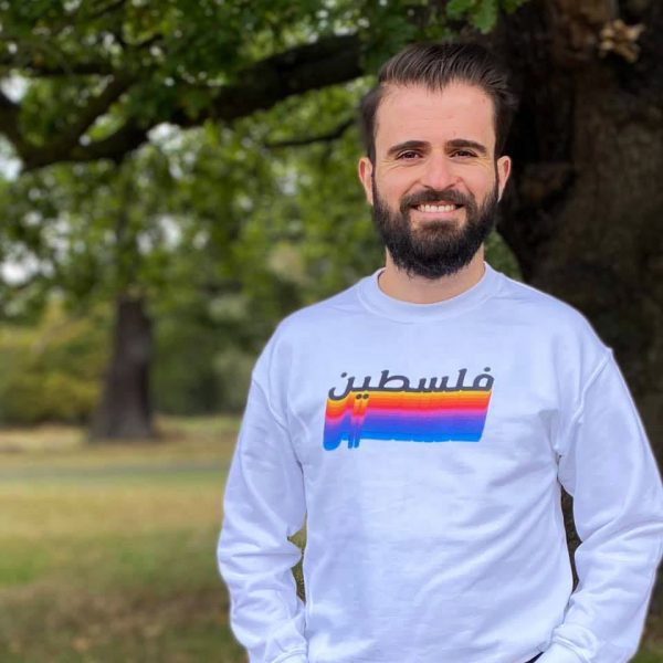 Elias in a park in a white long-sleeved top